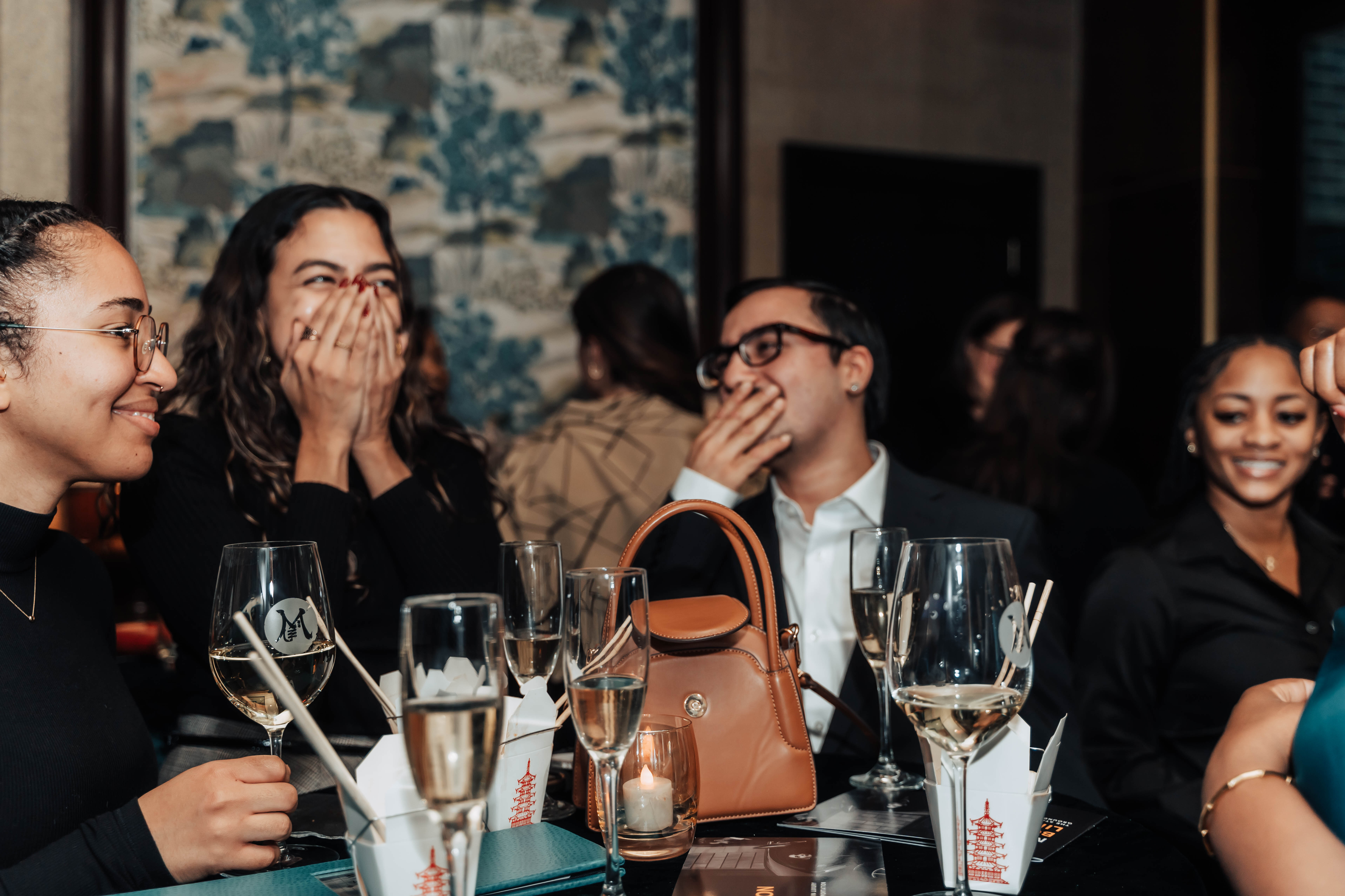 A diverse group of executive assistants and chiefs of staff in conversation at a private EA Society dinner.
